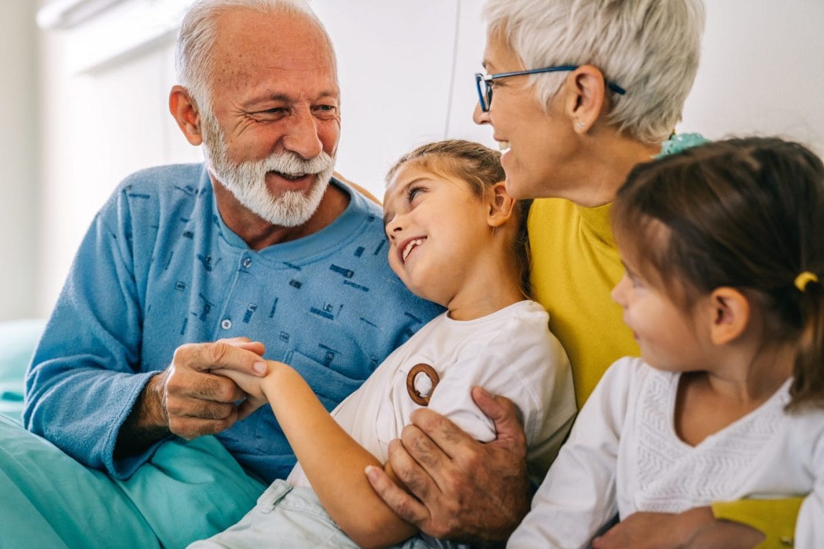 Elderly man and woman with young girls in conversation