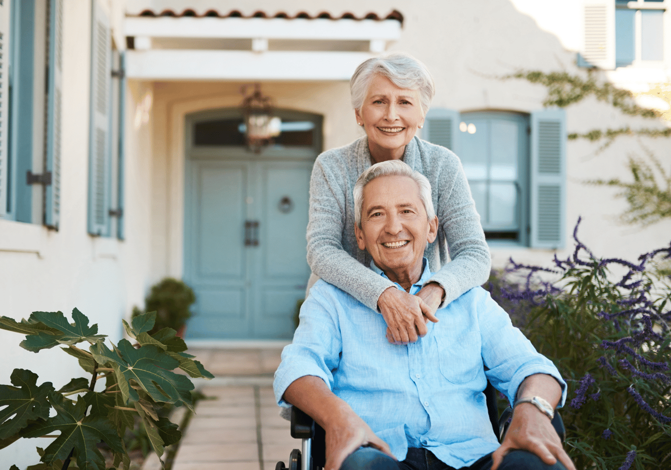 Smiling elderly couple outside a building.
