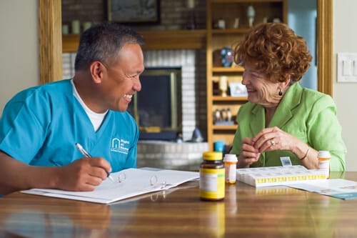 Staff member assisting senior with medication review.