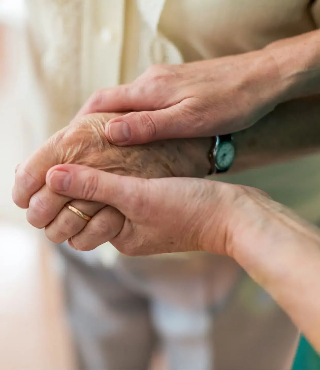 Two hands holding each other in a caring gesture.