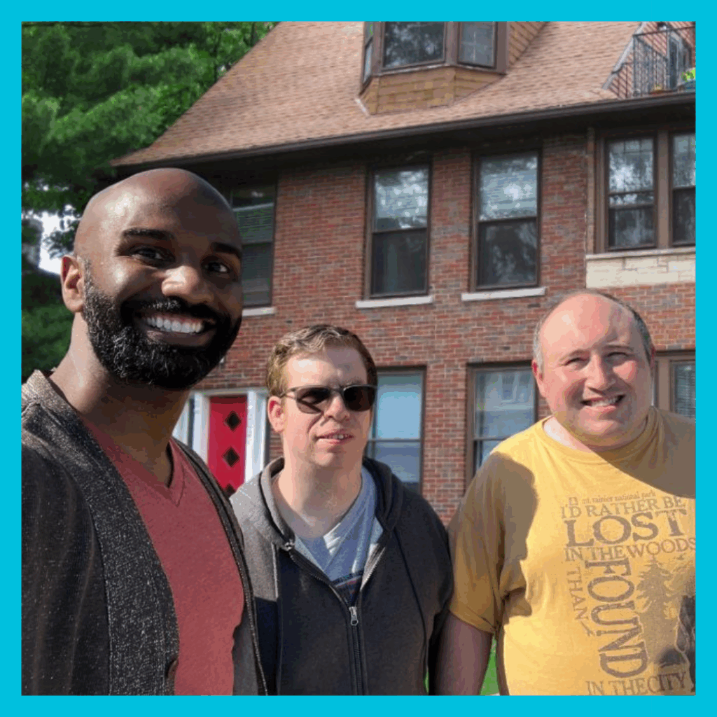 Three residents smiling in front of the facility building