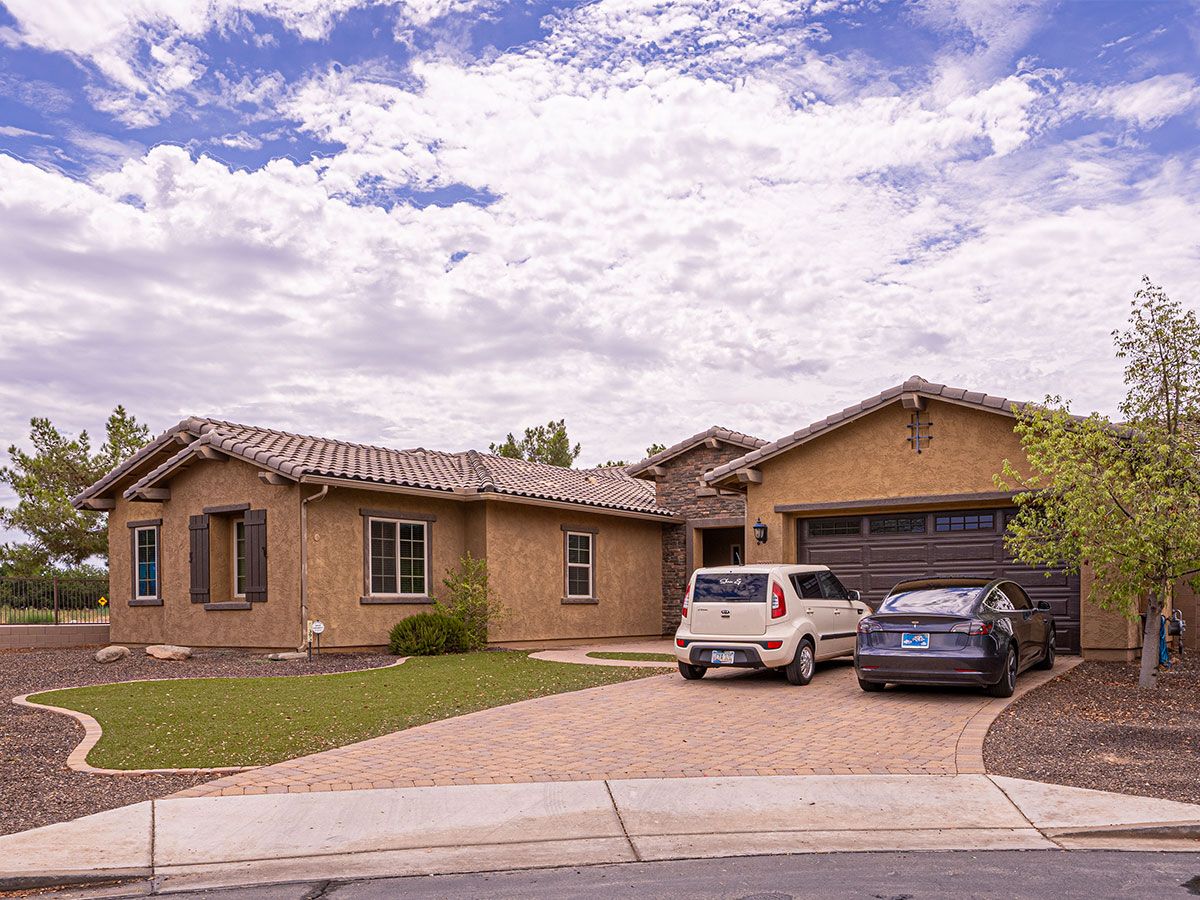 Exterior view of a residential building with cars in driveway