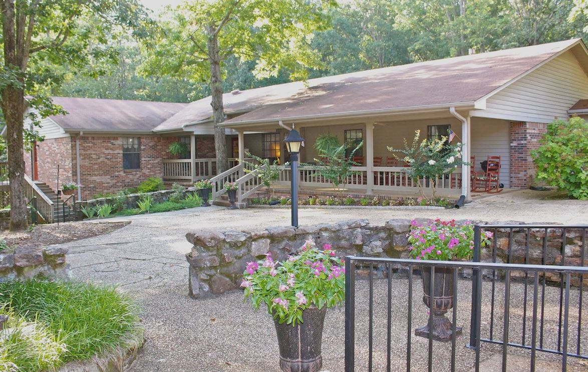 Exterior view of Green Oaks Inn with garden and seating area