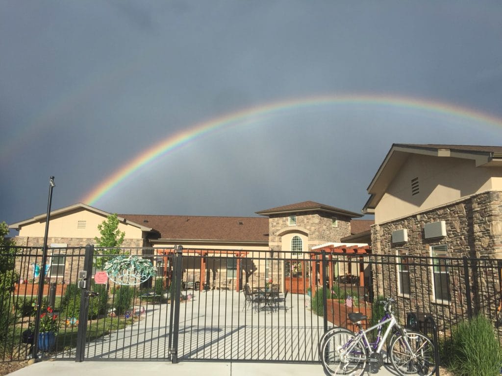 Exterior view of a nursing home with a rainbow