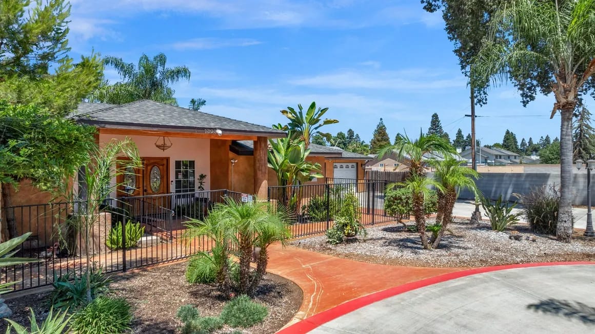 Exterior view of the Glory Days Memory Care facility with a garden