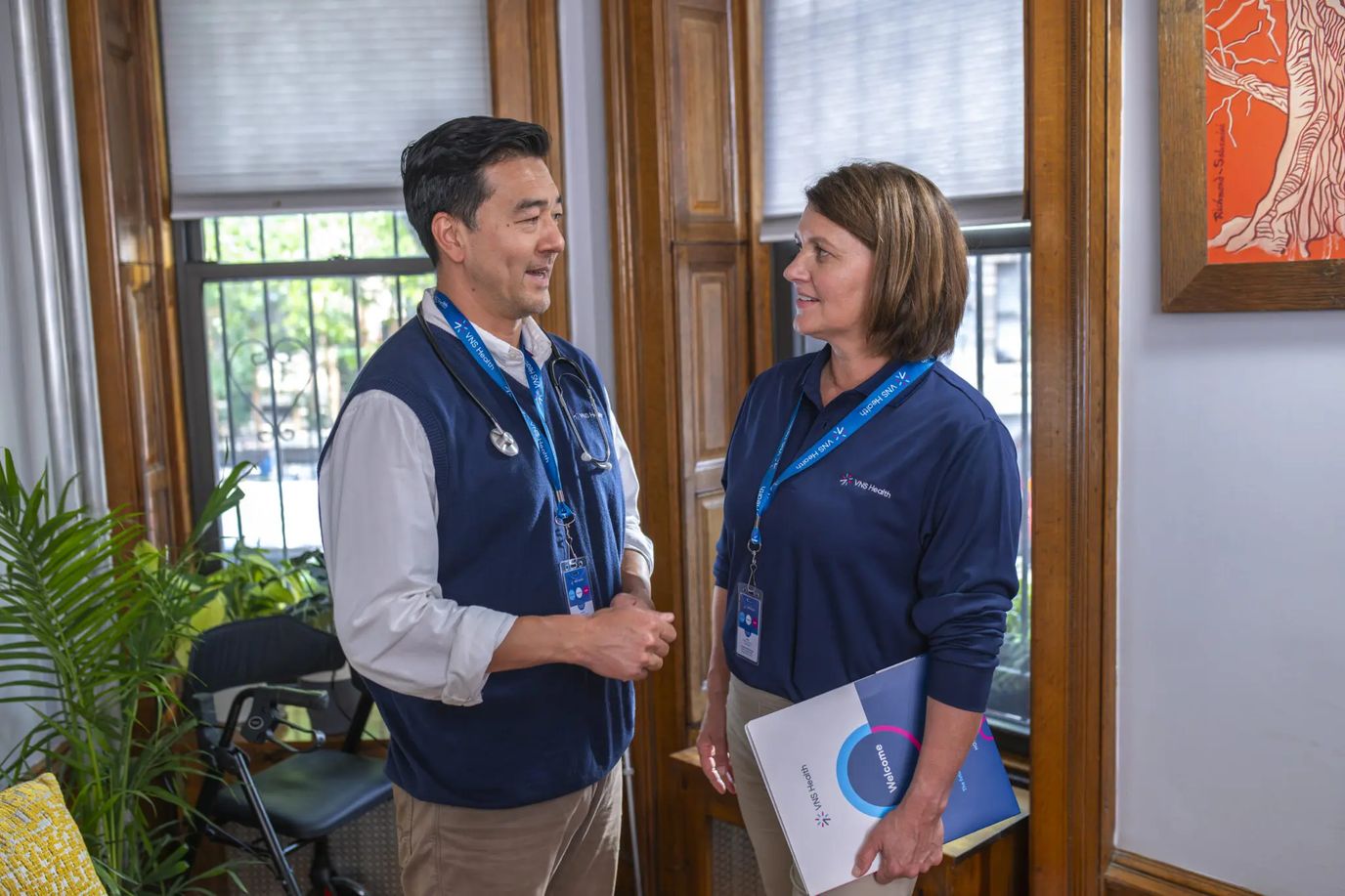 Two staff members engaging in conversation indoors