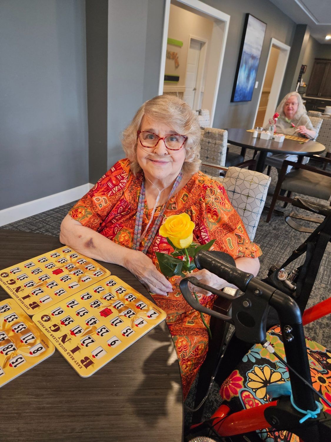 Vivera Senior Living of Jeffersonville, assisted living in Jeffersonville, IN — Senior resident holding a yellow rose at a bingo game