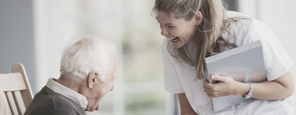 A staff member sharing a joyful moment with a resident