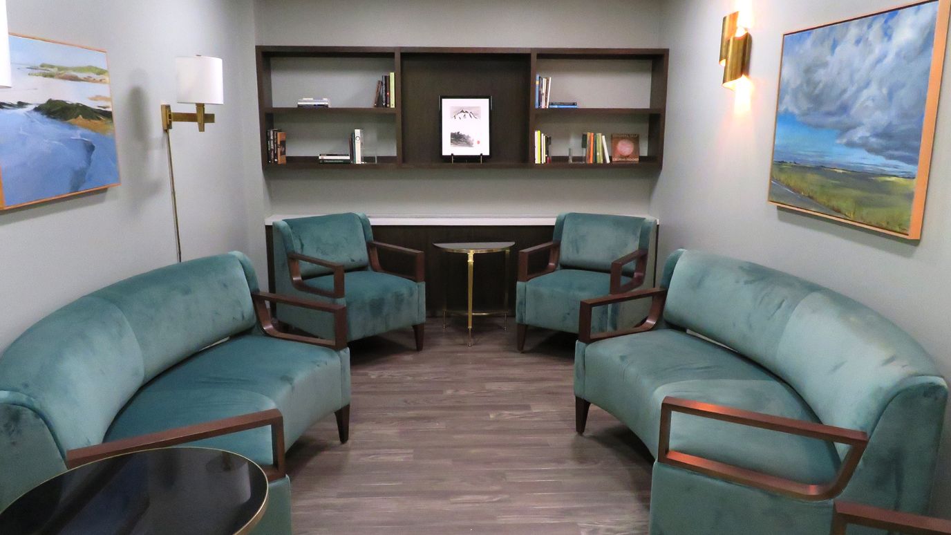 Cozy seating area with teal chairs and bookshelves