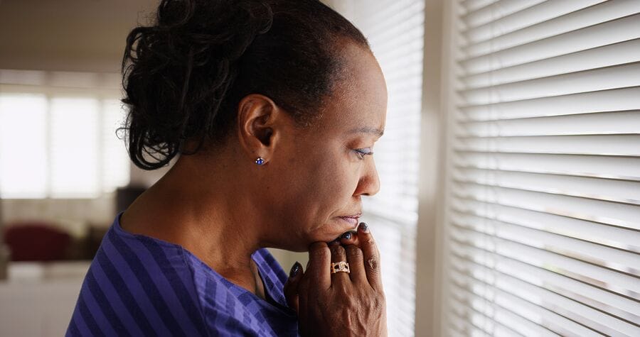 A woman looking contemplatively out a window.