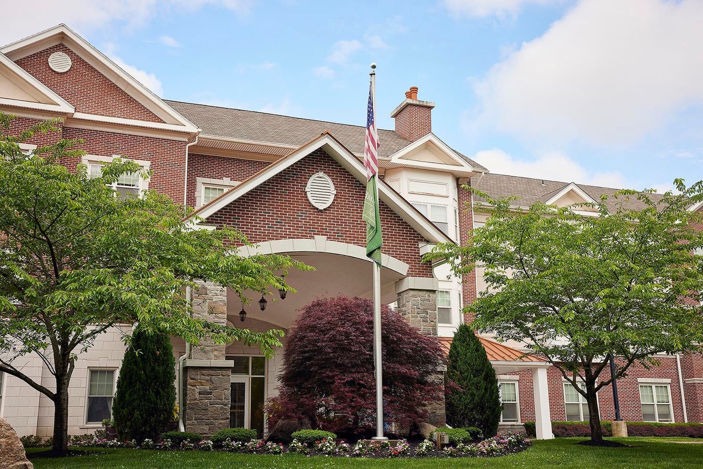 Brandywine The Savoy, assisted living in Queens, NY — Entrance of a senior living facility with landscaped grounds