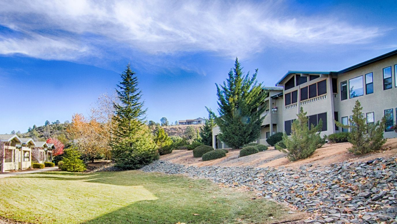 Exterior view of Evergreen Village Prescott surrounded by greenery