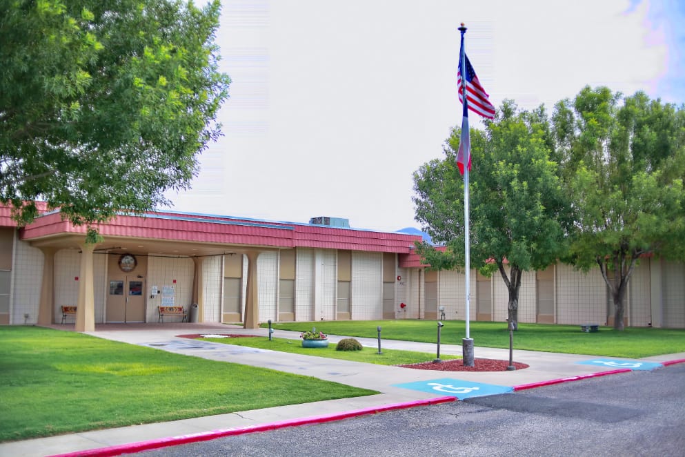 Exterior view of Franklin Heights Nursing and Rehab Center with flags and landscaped front area.