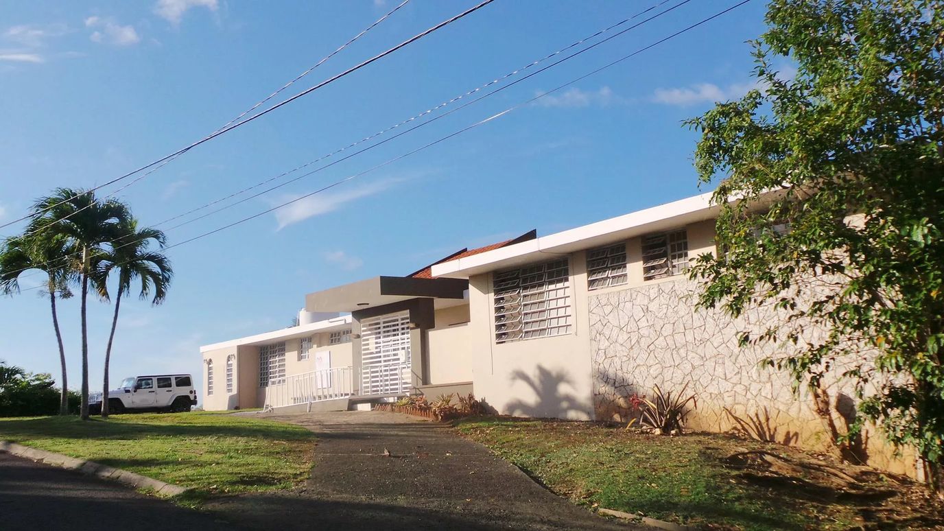 Front view of a senior care facility with palm trees