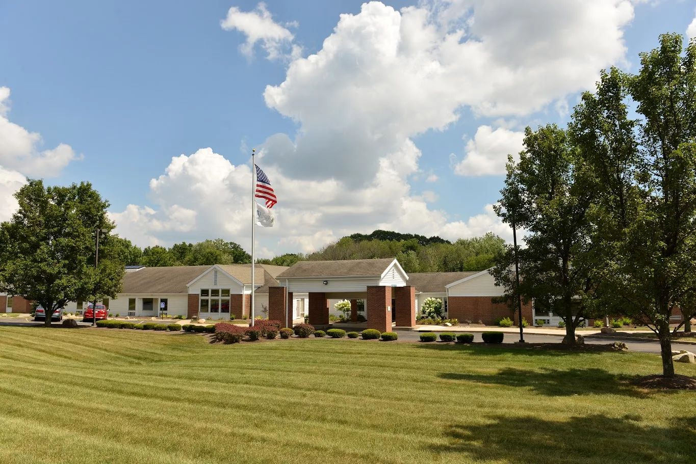 View of the facility exterior with flag and landscaping