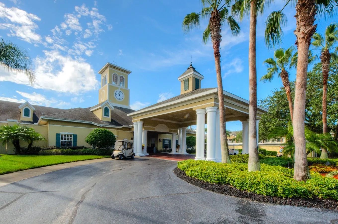 Front entrance of a senior living facility with palm trees