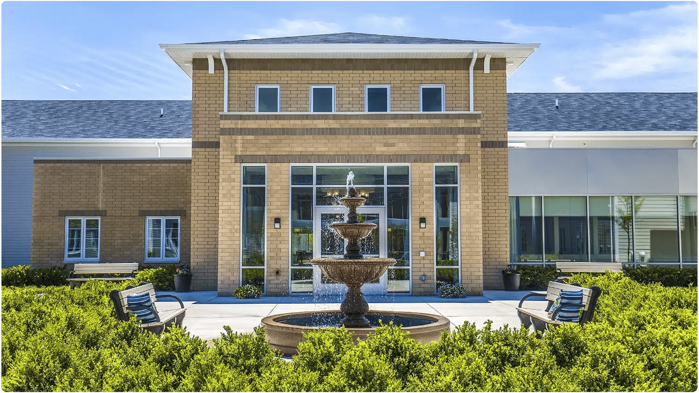 Exterior view of Montclair Senior Living facility with fountain