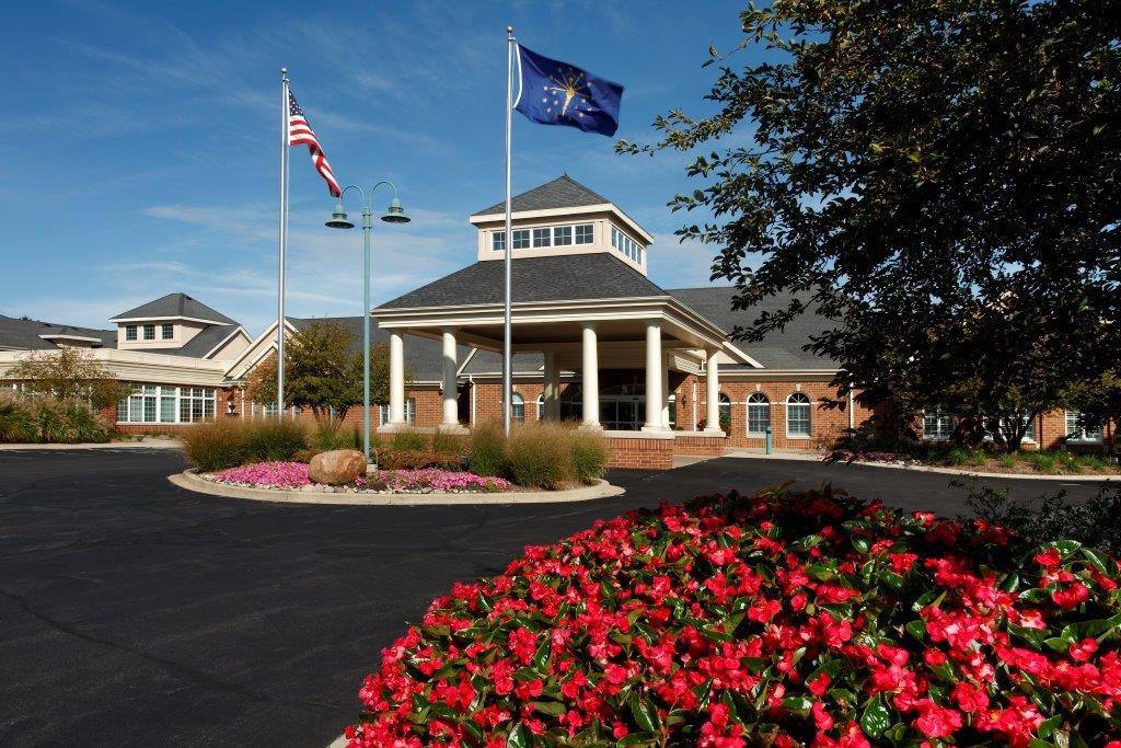 Exterior view of a senior living facility with flowers and flags