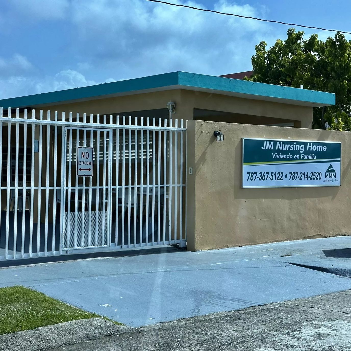 Exterior of JM Nursing Home with a gate and signage.