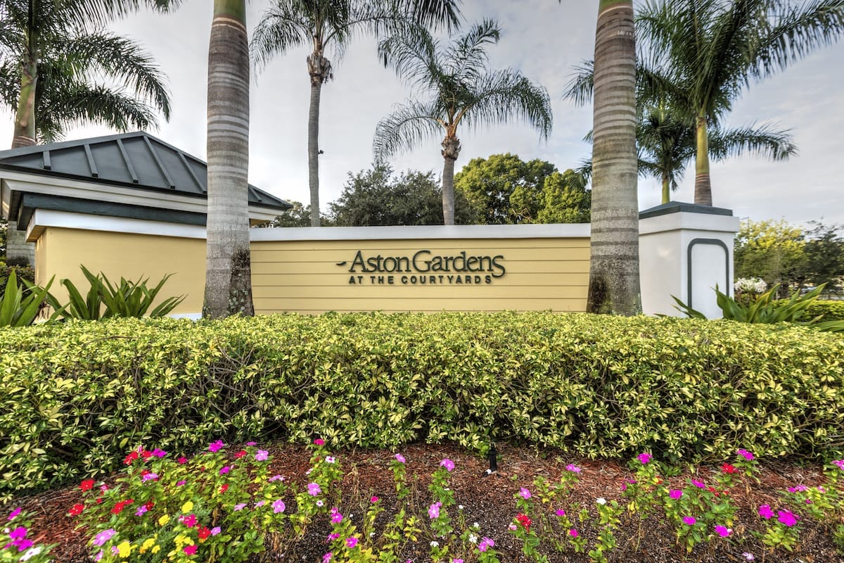 Exterior sign of Aston Gardens facility with landscaping
