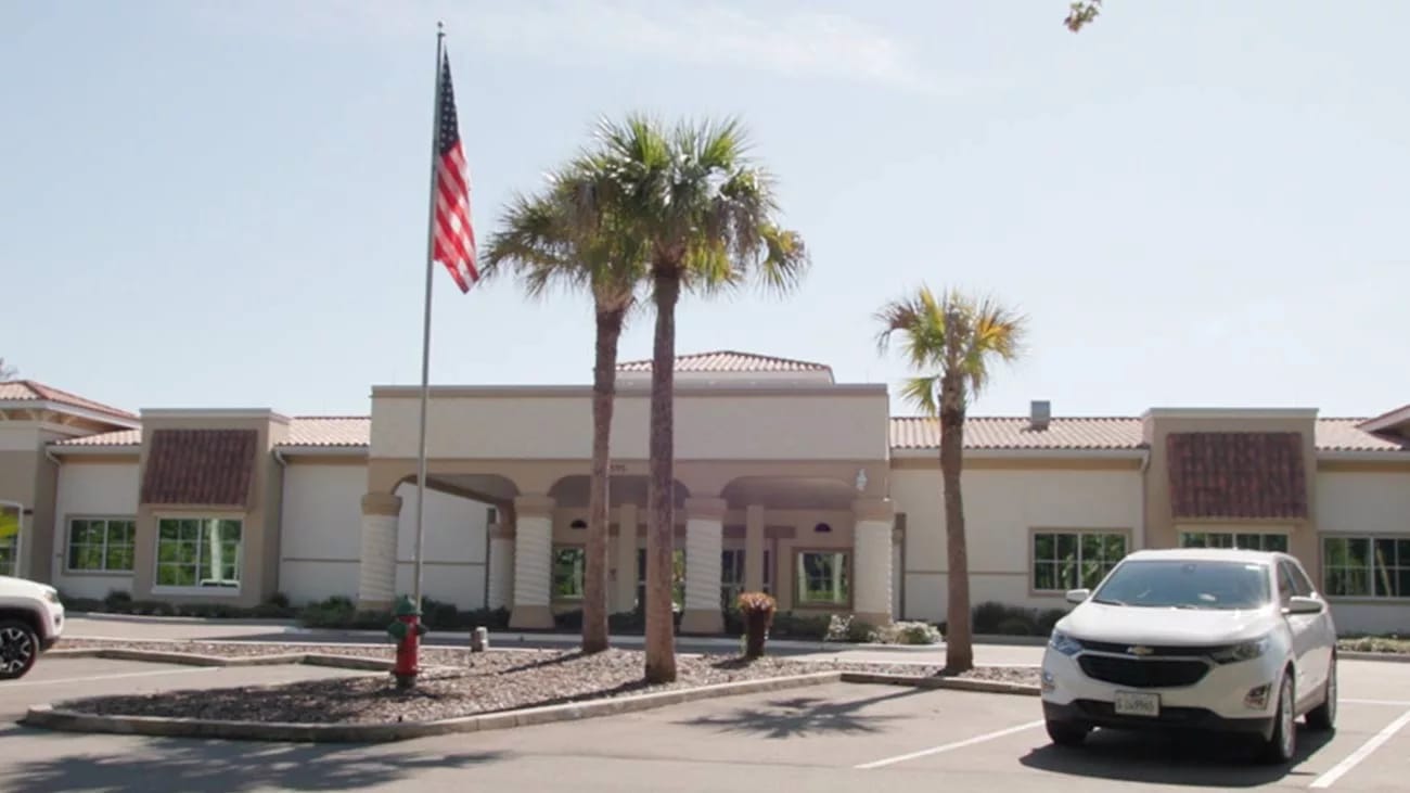 Exterior view of the nursing facility with palm trees
