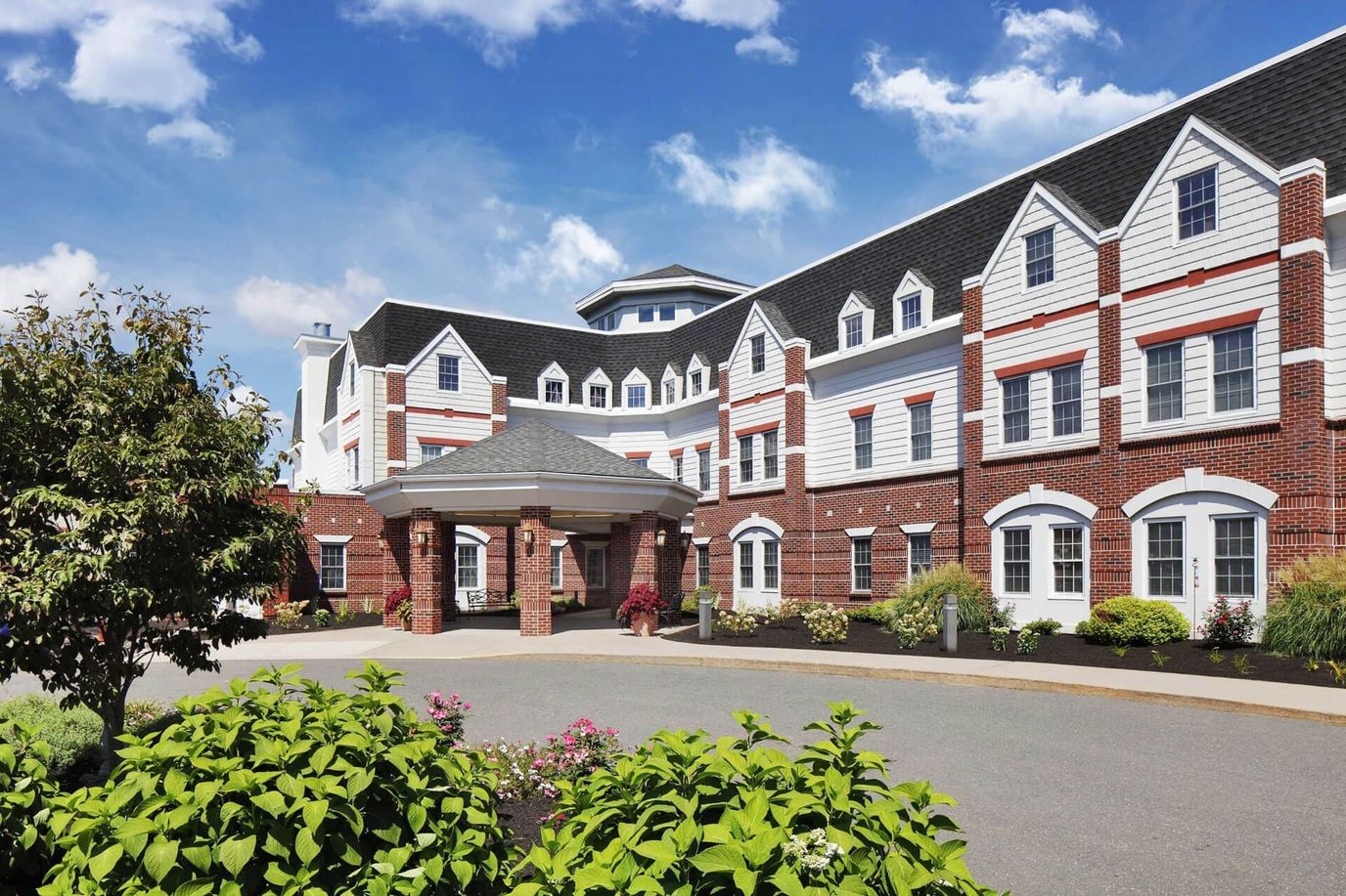Exterior view of a senior living facility with gardens