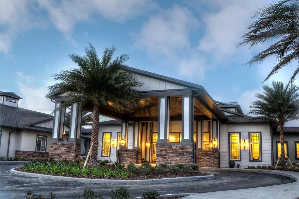 Exterior view of a senior living facility with palm trees