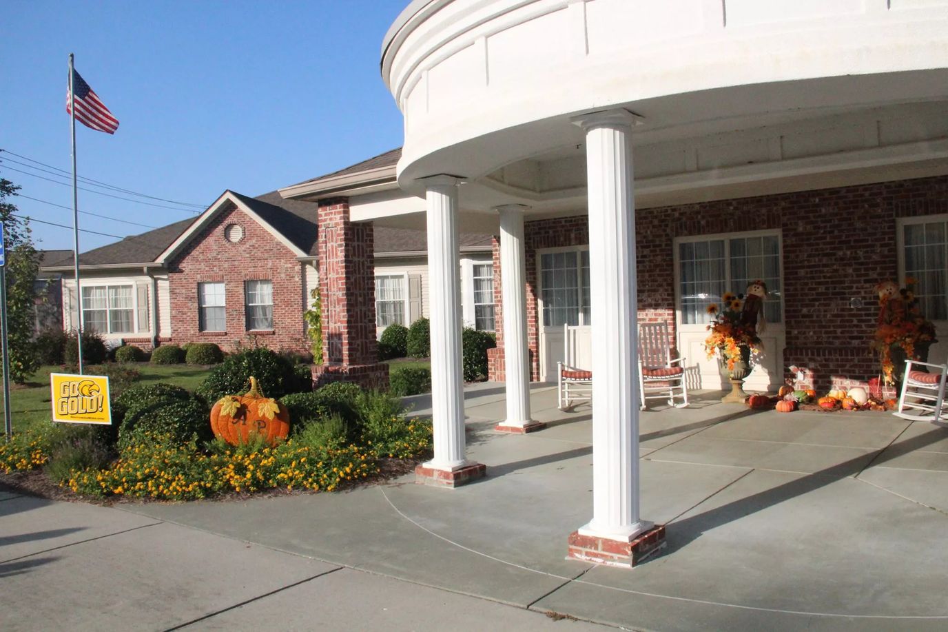 Entrance of a cozy assisted living facility with autumn decor