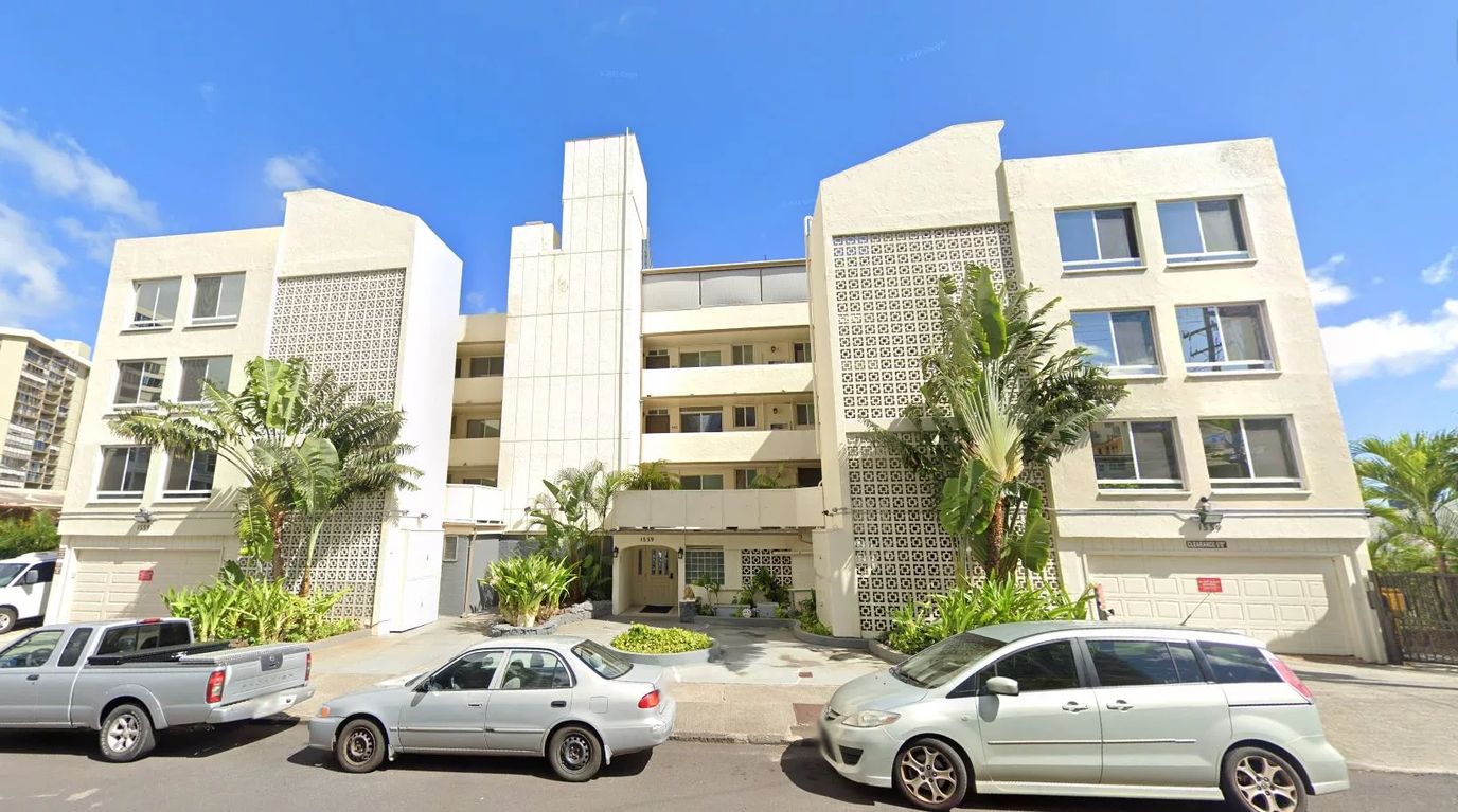 Exterior view of a senior living facility with palm trees