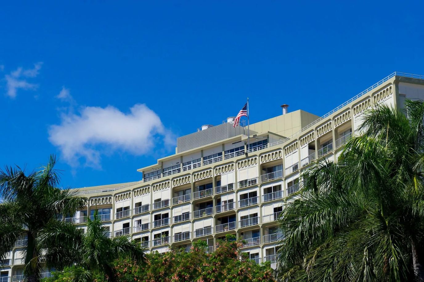 Exterior view of a senior living facility with palm trees