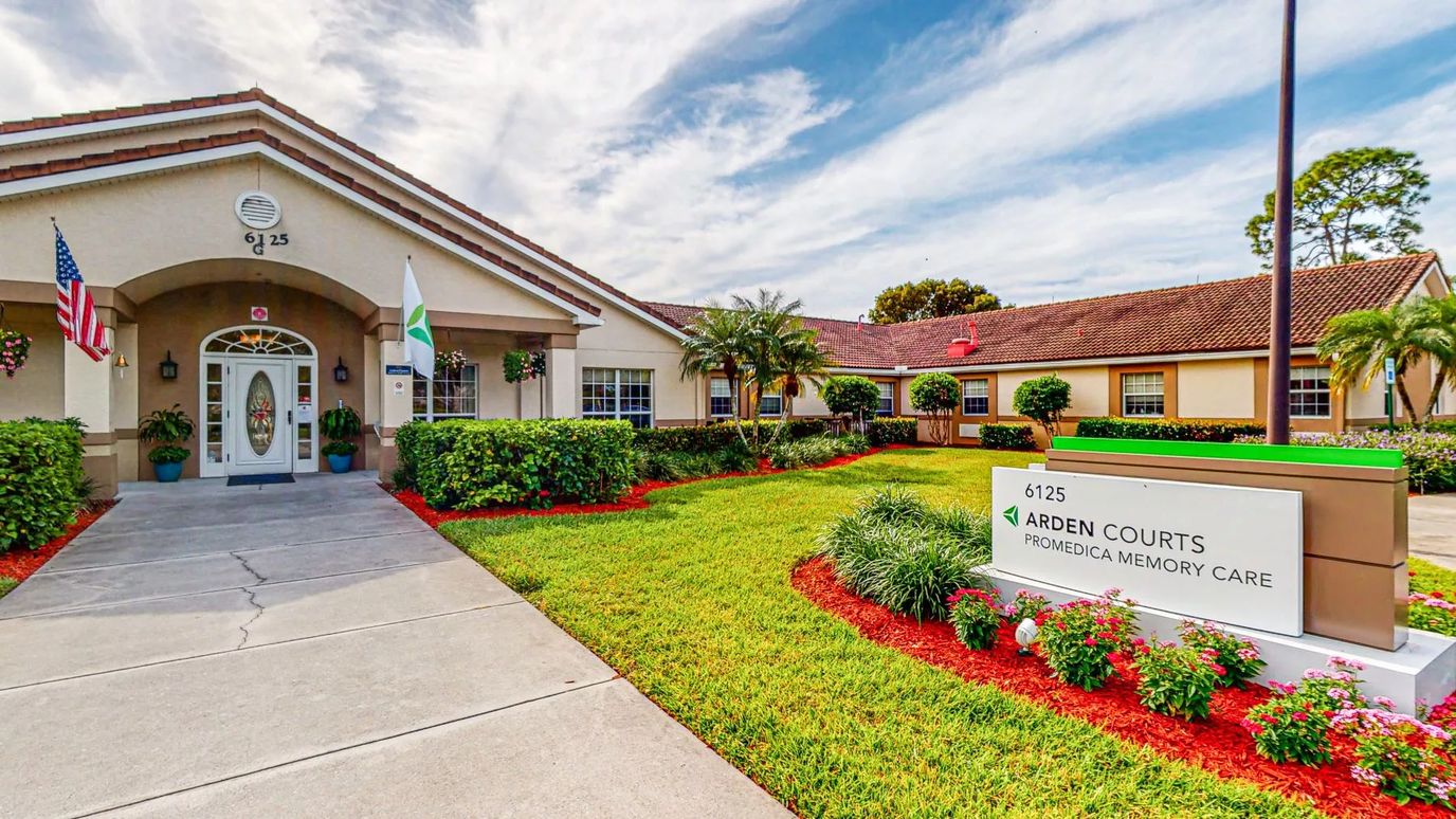 Exterior view of a senior living facility with gardens