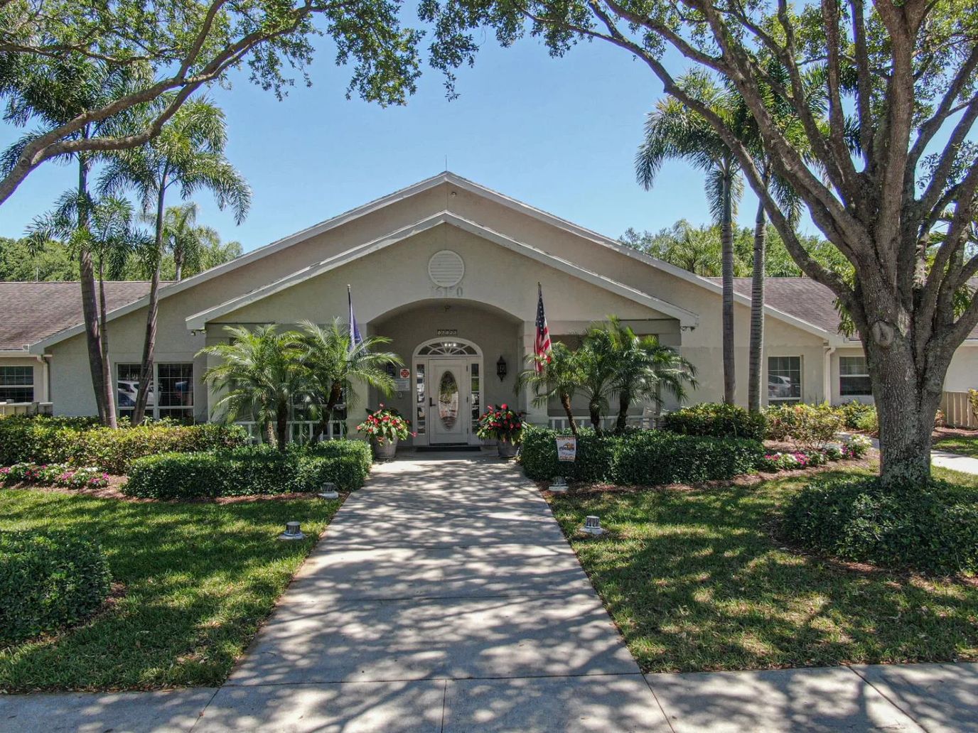 Front entrance of a senior living facility surrounded by greenery