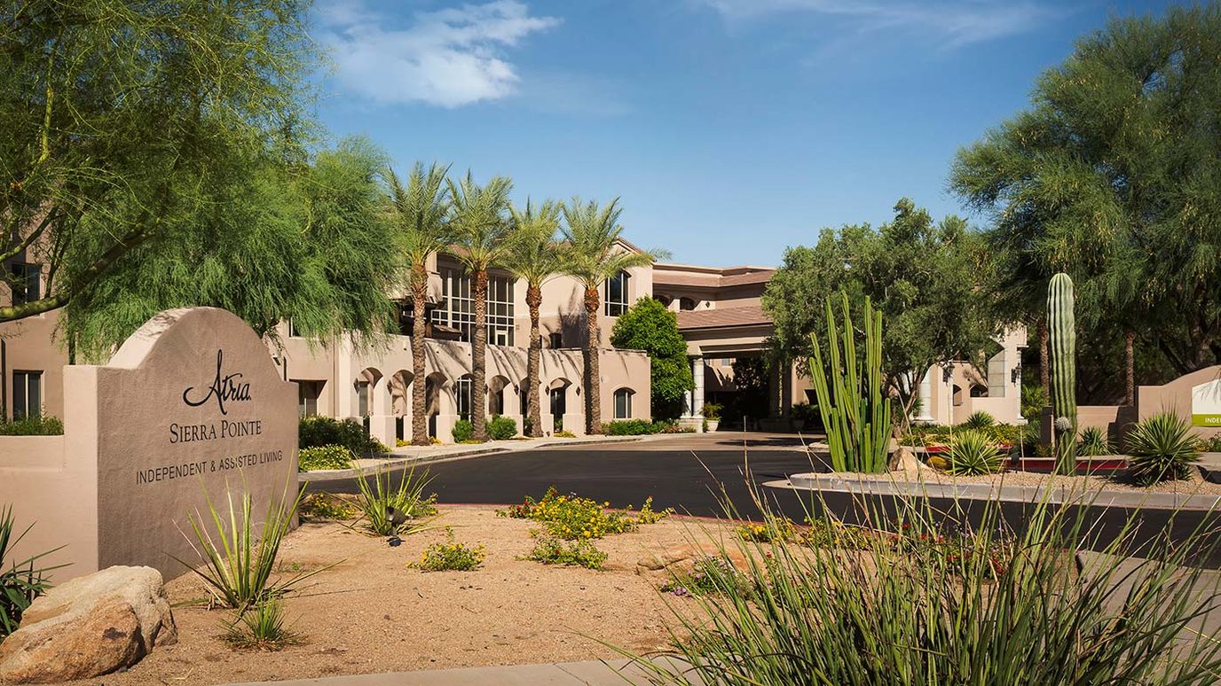 Exterior view of a senior living facility surrounded by landscaping