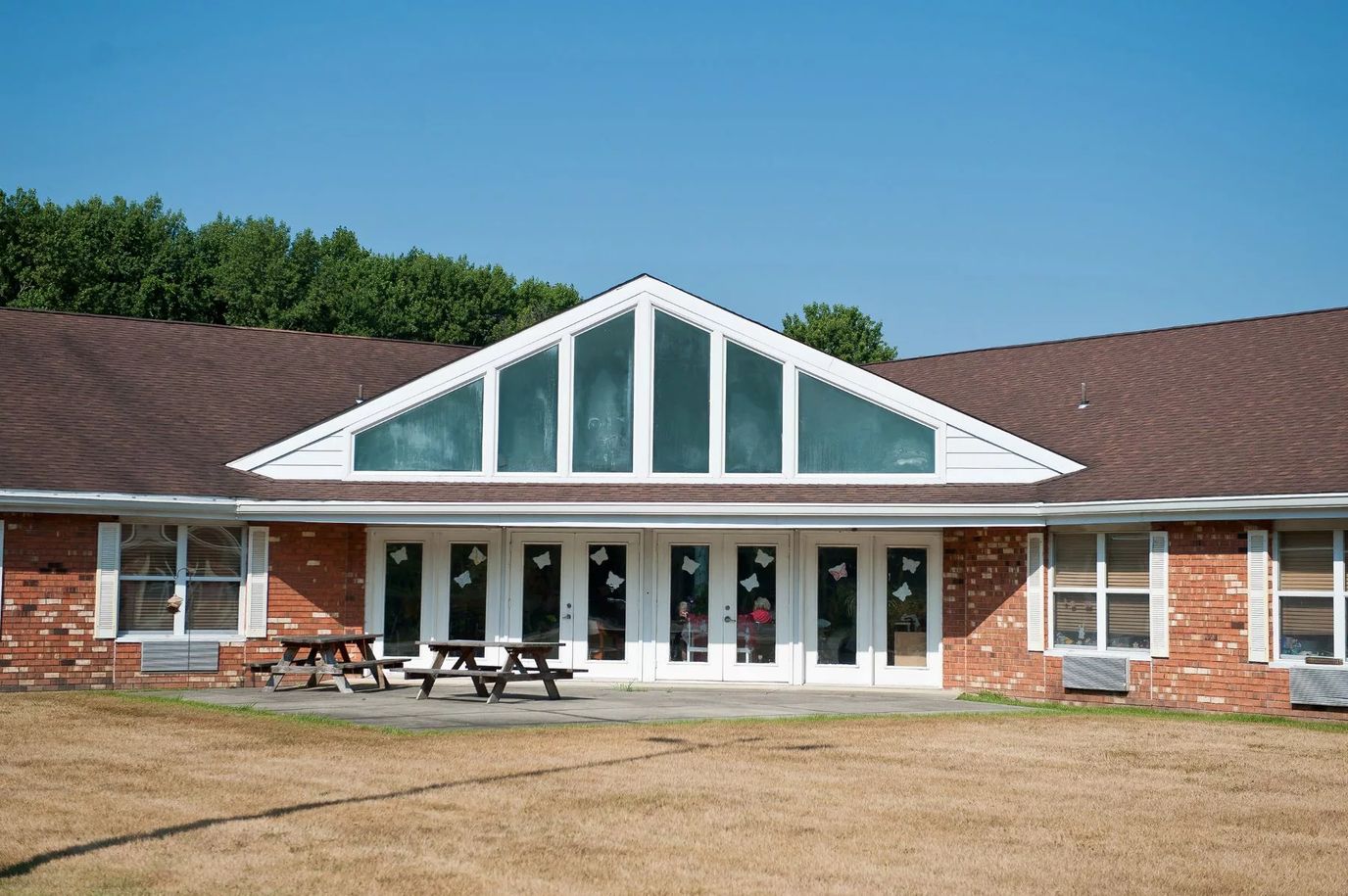Exterior view of a senior living facility with outdoor seating