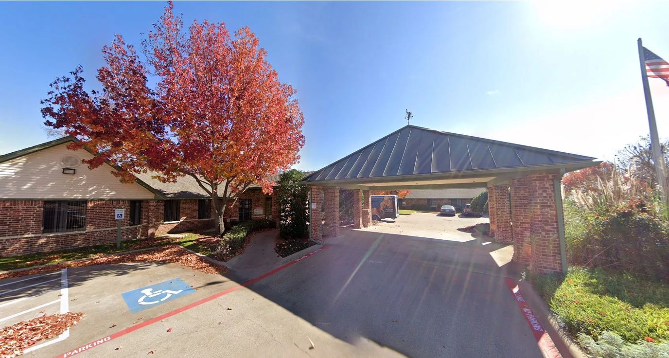 Entrance of a senior living facility with autumn trees