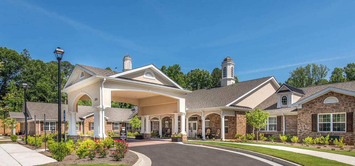Exterior view of a senior living facility with flowers and landscaping