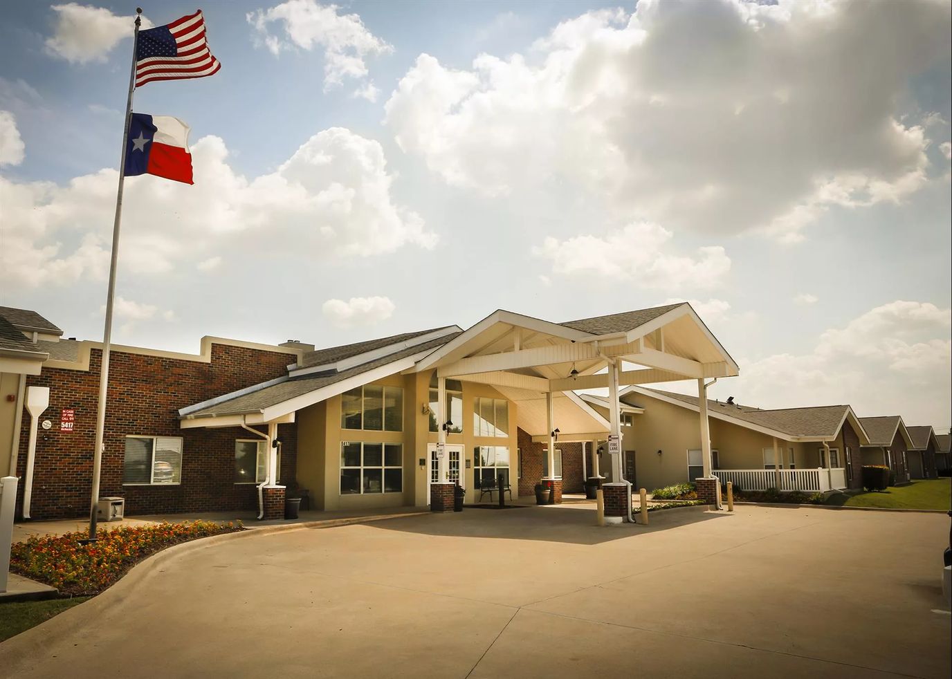 Front entrance of a senior living facility with flags