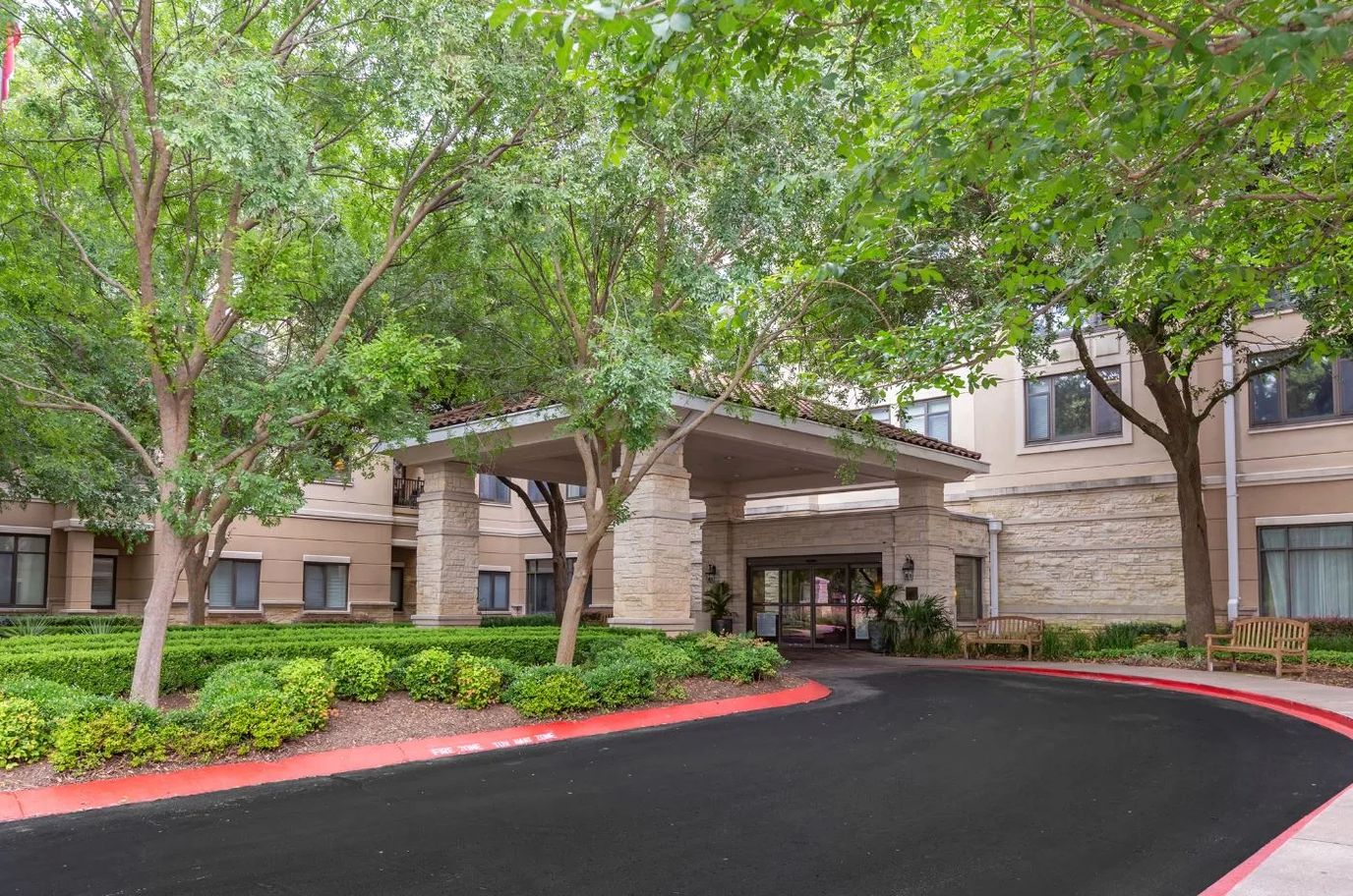 Entrance of a senior living facility with trees