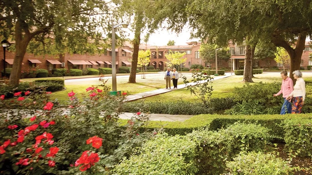 Claremont Village Assisted Living, Assisted Living in Bronx, NY — Residents walking through a landscaped outdoor area