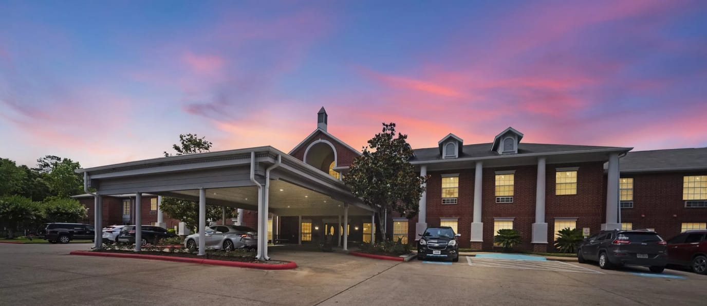 Front entrance of a senior living facility at sunset