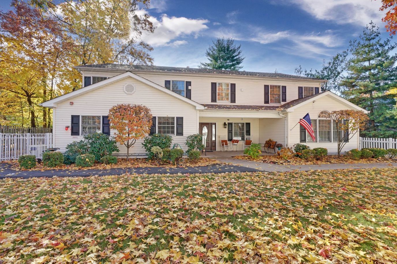 Front view of a senior living facility surrounded by fall leaves.