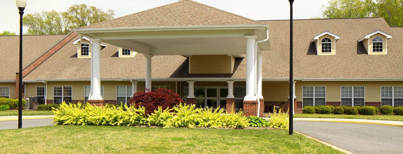 Front entrance of a senior living facility with outdoor landscaping