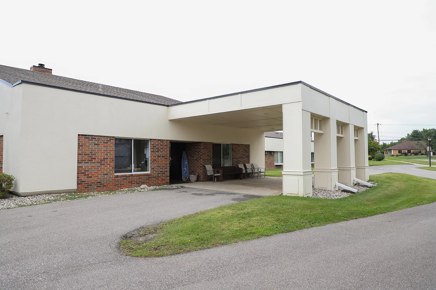 Exterior view of a nursing home entrance with outdoor seating
