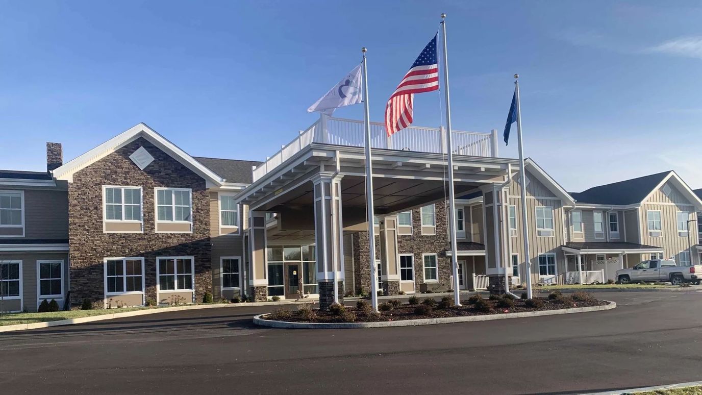 Front entrance of Legacy Living Florence with flags