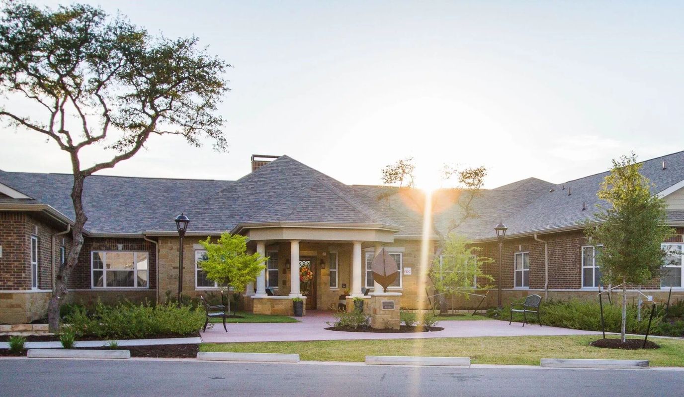 Exterior view of the facility with landscaping and sunset