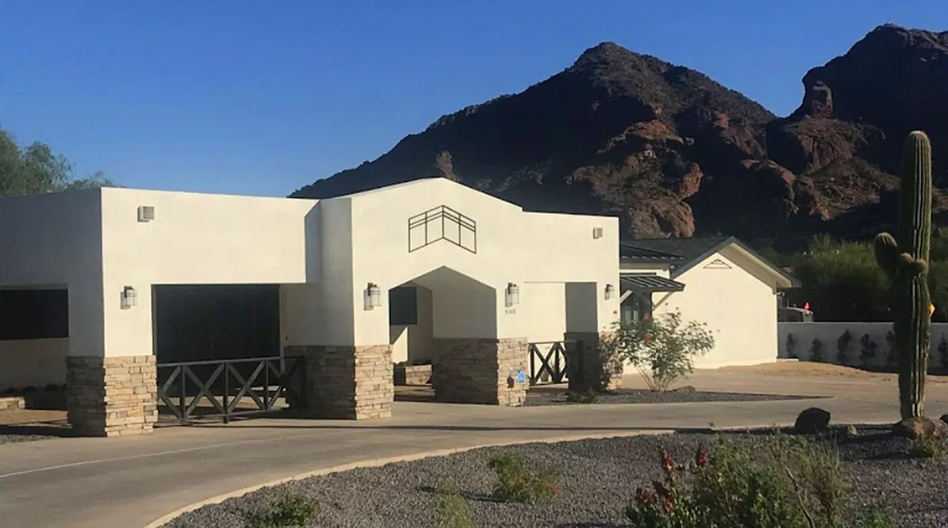 Exterior view of a residential assisted living facility with mountains