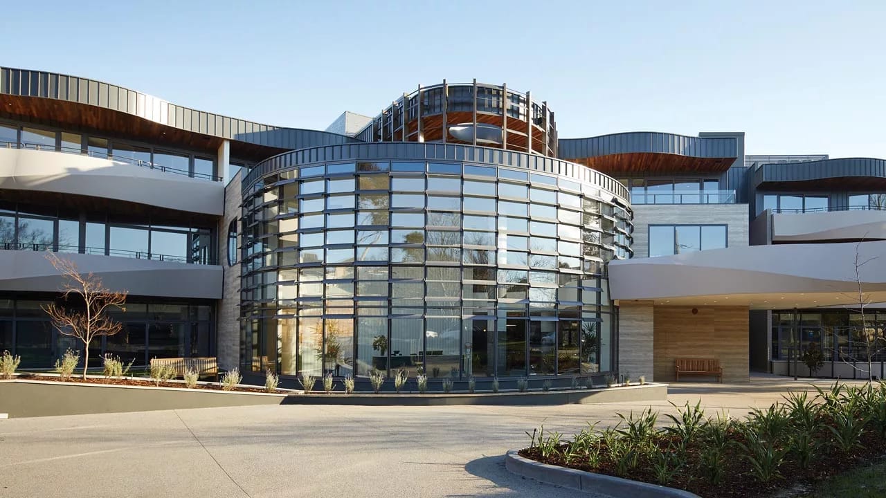 Modern healthcare facility exterior with glass and greenery