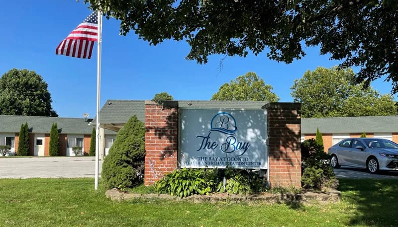 Facility sign and entrance with landscaping