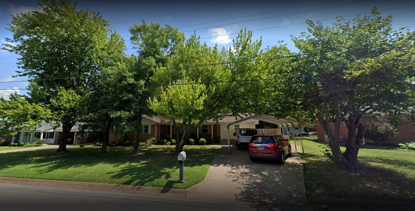 Exterior view of a senior living facility surrounded by trees
