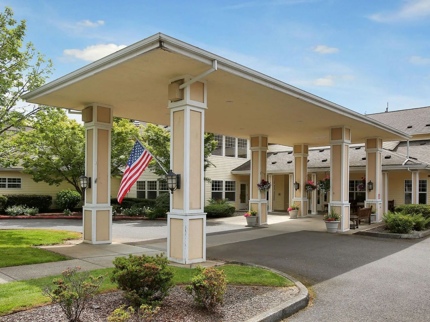 Entrance of Prestige Senior Living Huntington Terrace with American flag